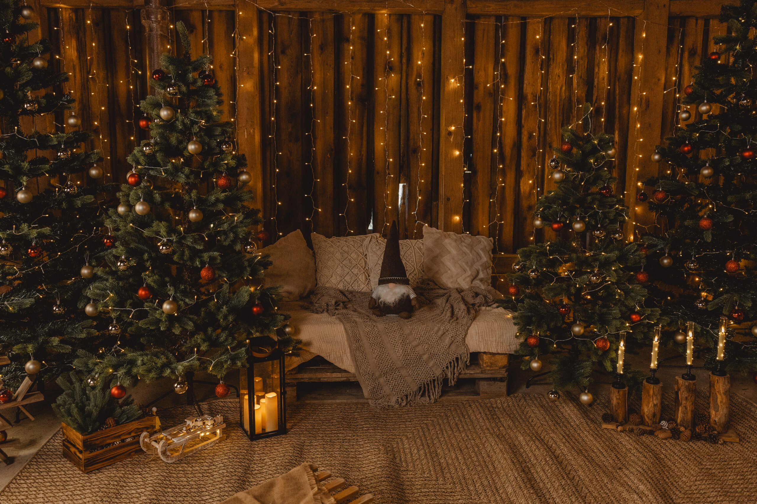 Weihnachtskulisse 2026 mit Sofa, Tannenbäumen und warmen Lichterketten